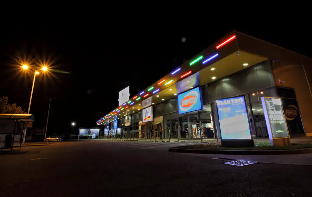 Noční nasvícení komerční budovy s instalací barevných světel