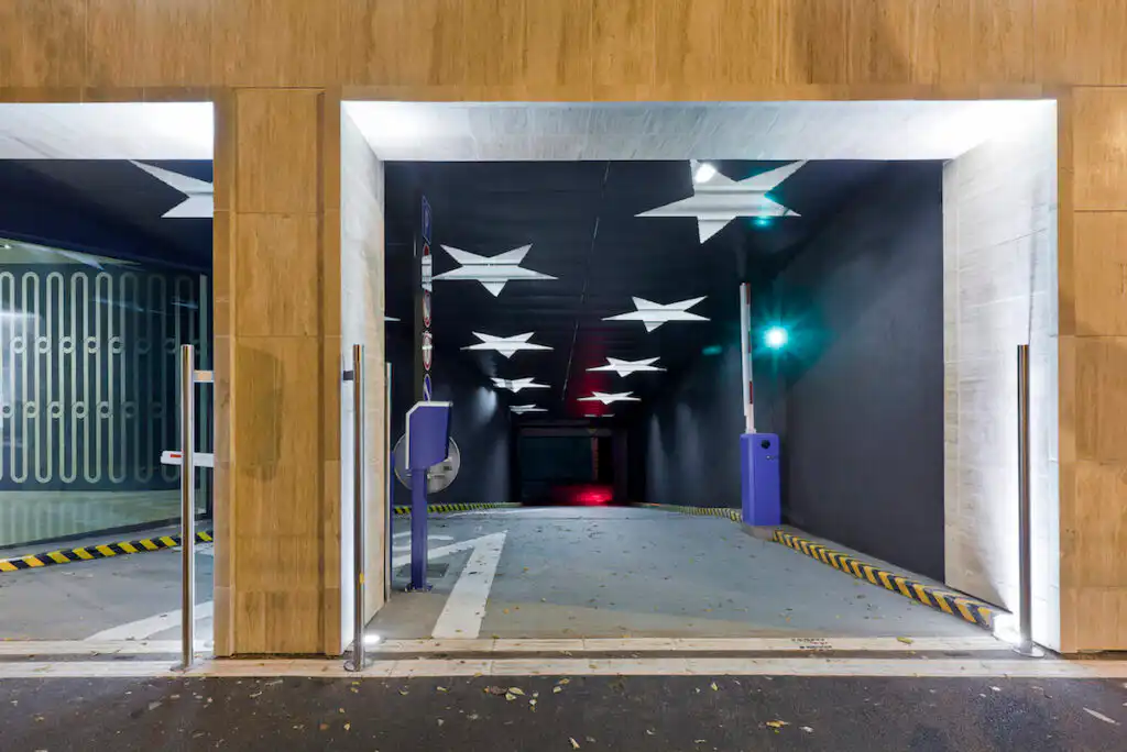 Podsvícený podhled vjezdu do garáží s fasádní perforací ve tvaru hvězd