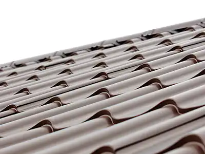 Plechové střechy: Detail profilované plechové střešní krytiny DEKMETAL s vzhledem klasické tašky