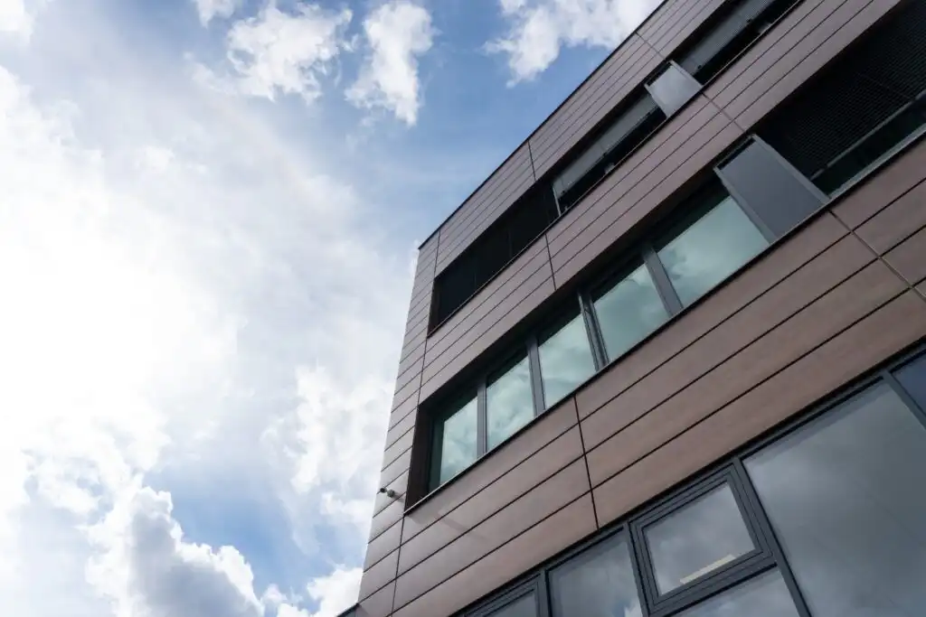 Architektonické řešení fasády s využitím imitace tmavých cortenových plechů.