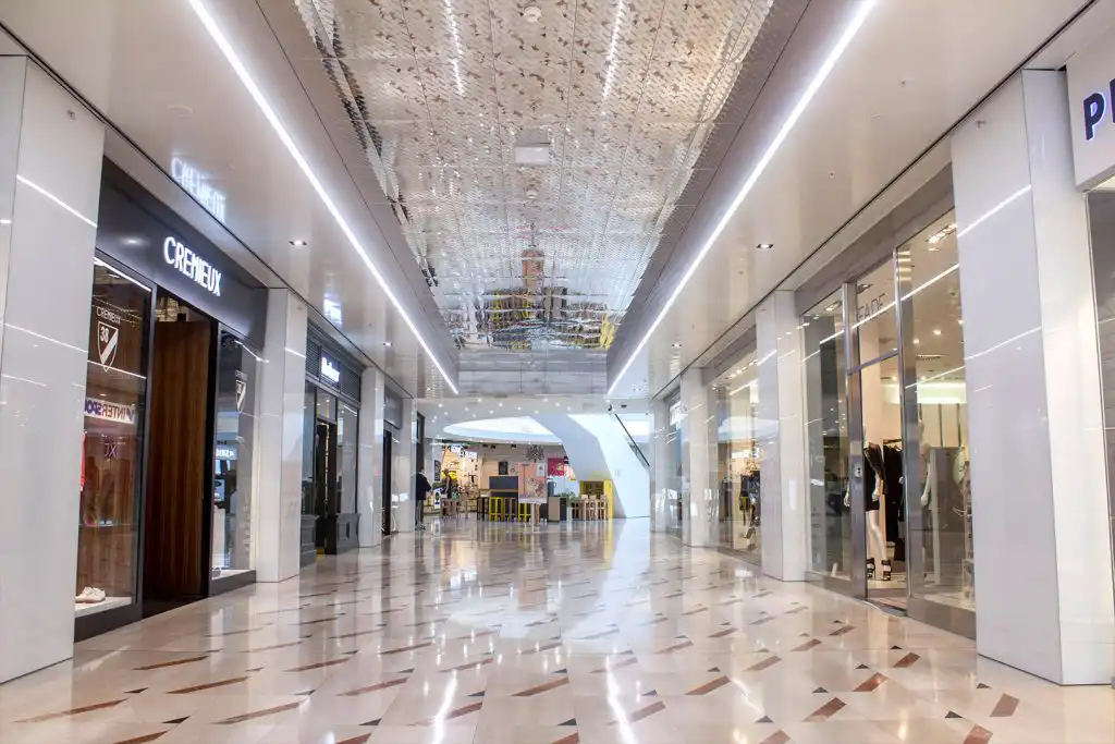 Interiérový nerezový podhled DEKMETAL v provedení Super Mirror instalovaný v galerii MYSLBEK – vysoce lesklý designový obklad pro moderní a reprezentativní interiéry.