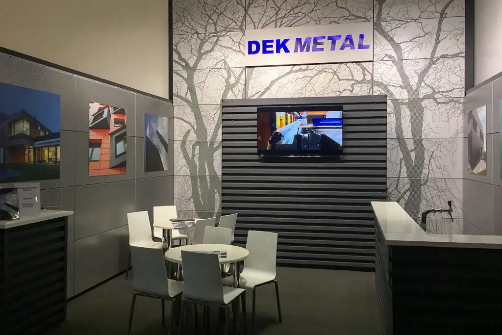 Výstavní stánek BAU s perforovaným stromem na kazetách DEKCASSETTE a obkladem DEKPROFILE FOR ARCHITECT. Vysekaný nápis DEKMETAL