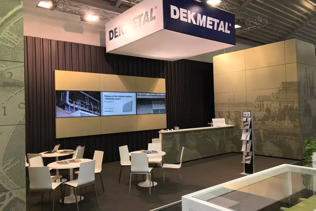 Stánek BAU „Zlatá Praha“ s designovou perforací pražského orloje a Hradčan na plechových kazetách DEKMETAL pro odvětrávané fasády, interiéry i podhledy