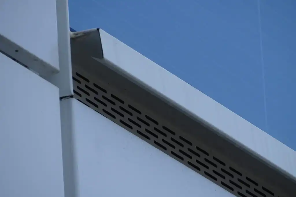 Detail odvětrávacího prvku s fasádní perforací na parapetu budovy