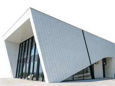 Moderní architektura administrativní budovy s bílou provětrávanou fasádou DEKMETAL