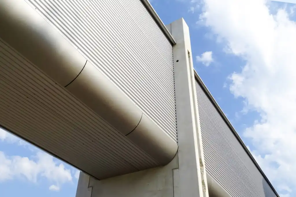Kombinace fasádního profilu DEKPROFILE a obloukových kazet DEKCASSETTE na spojovacím můstku MADETA, detail moderní kovové fasády
